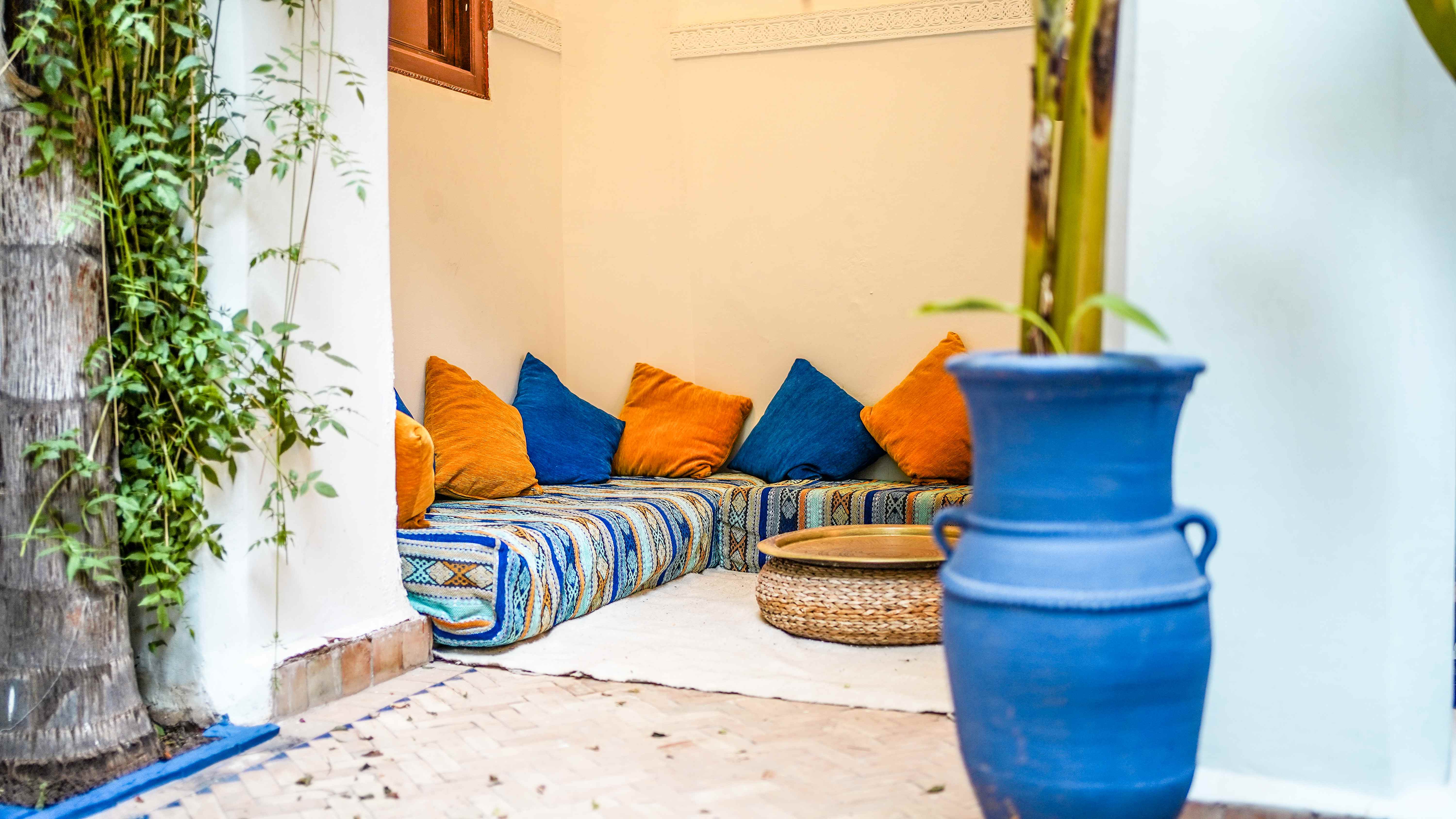 Coin salon marocain avec coussins bleus et oranges